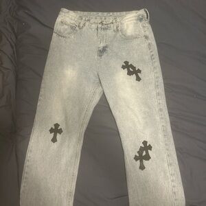 Chrome Hearts pants. Light blue denim with black leather crosses.
